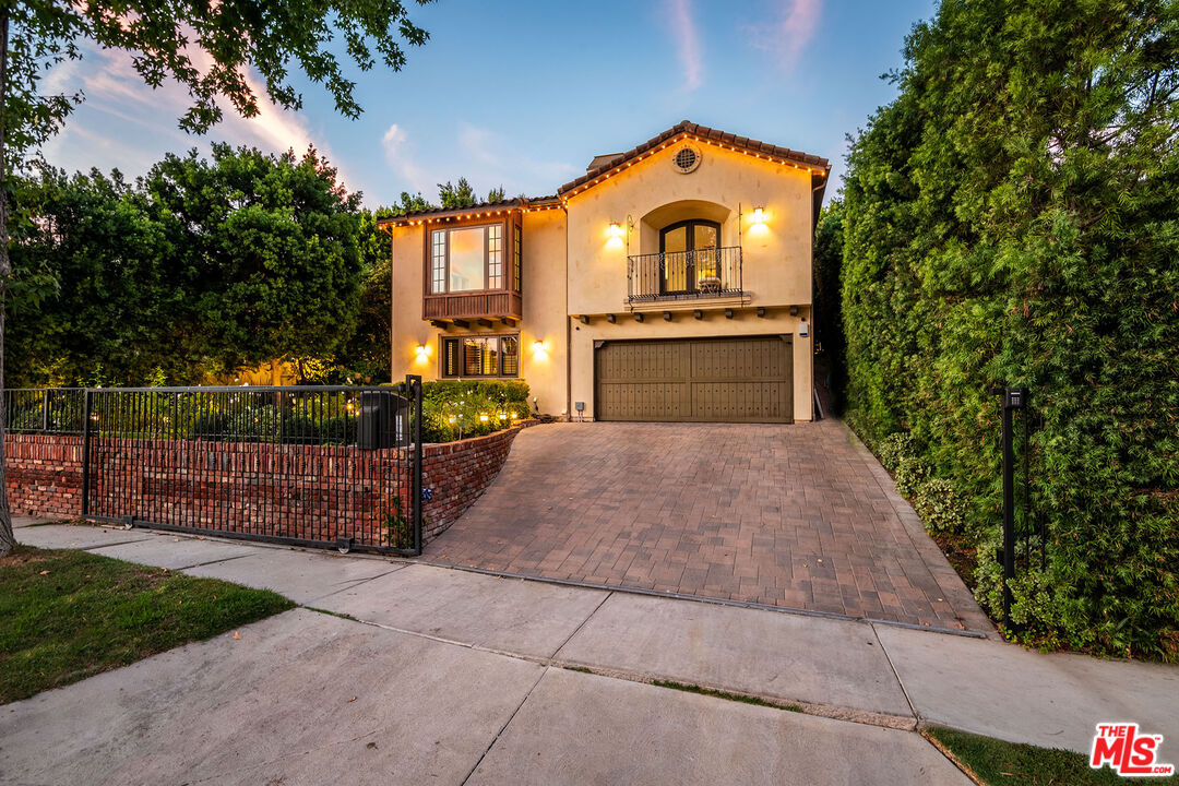 a front view of a house with a garden and garage