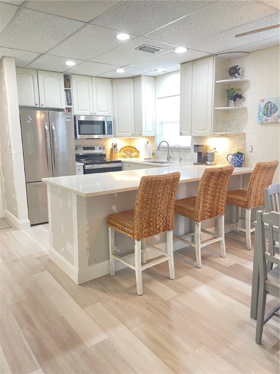 a kitchen with stainless steel appliances granite countertop a table chairs refrigerator sink and cabinets