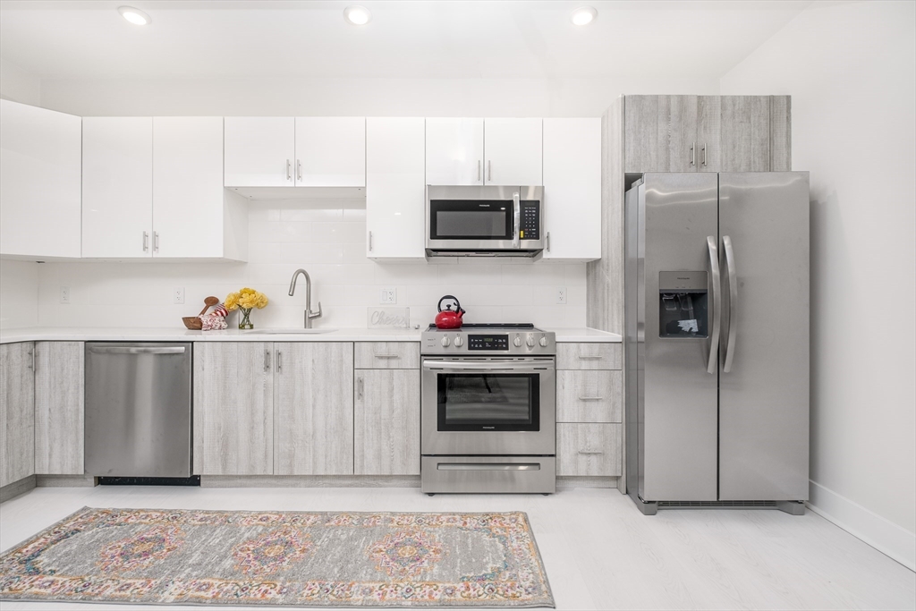 a kitchen with stainless steel appliances granite countertop a refrigerator sink and cabinets