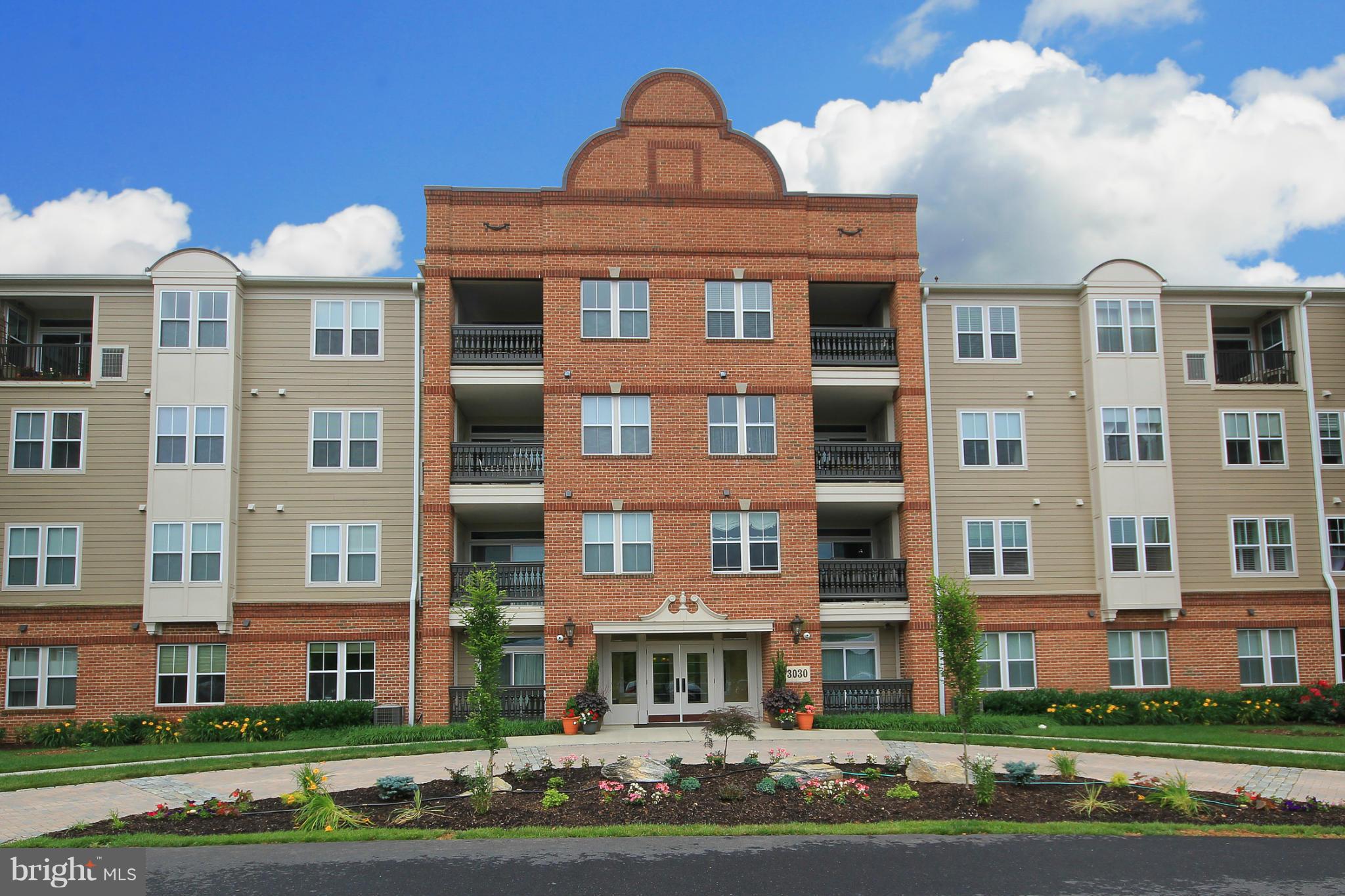 a front view of a residential apartment building with a yard