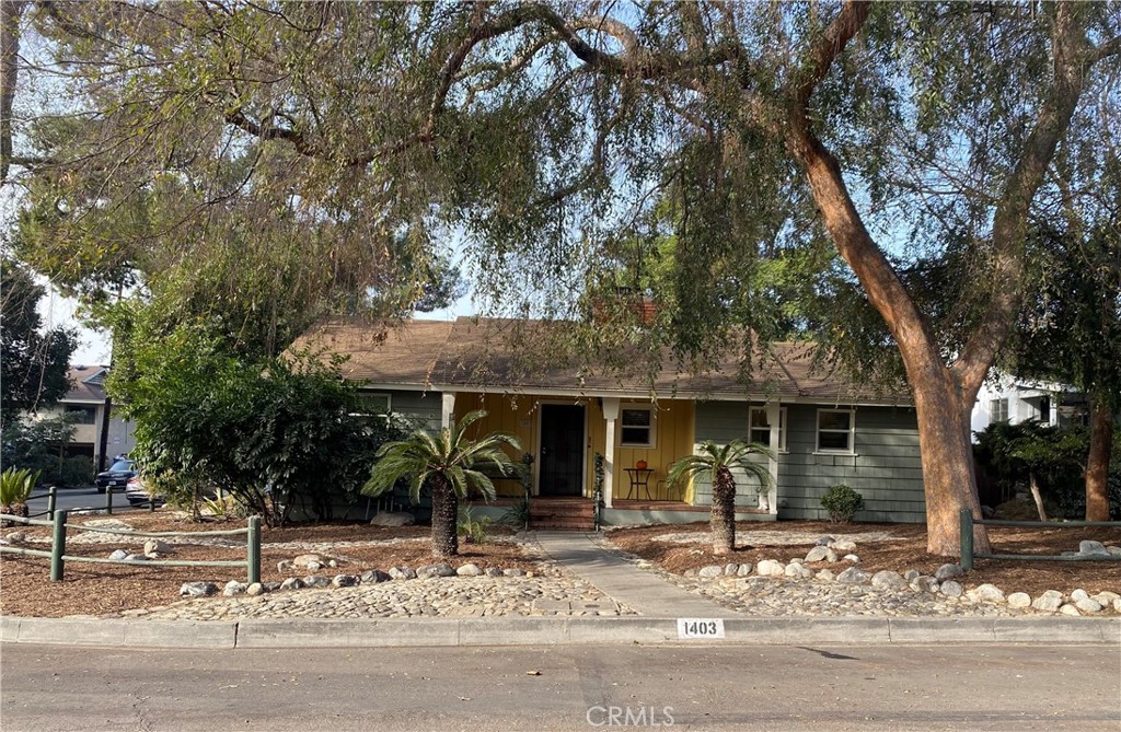 a front view of a house with garden and trees