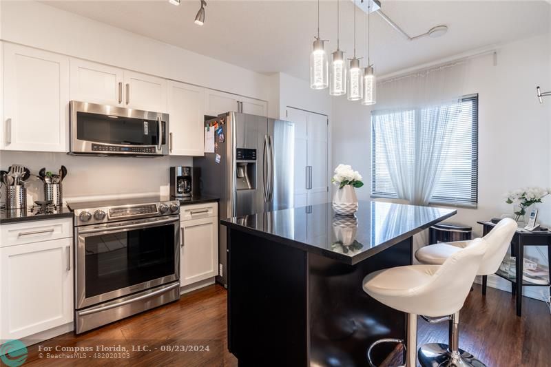 a kitchen with stainless steel appliances granite countertop a stove a sink and a refrigerator