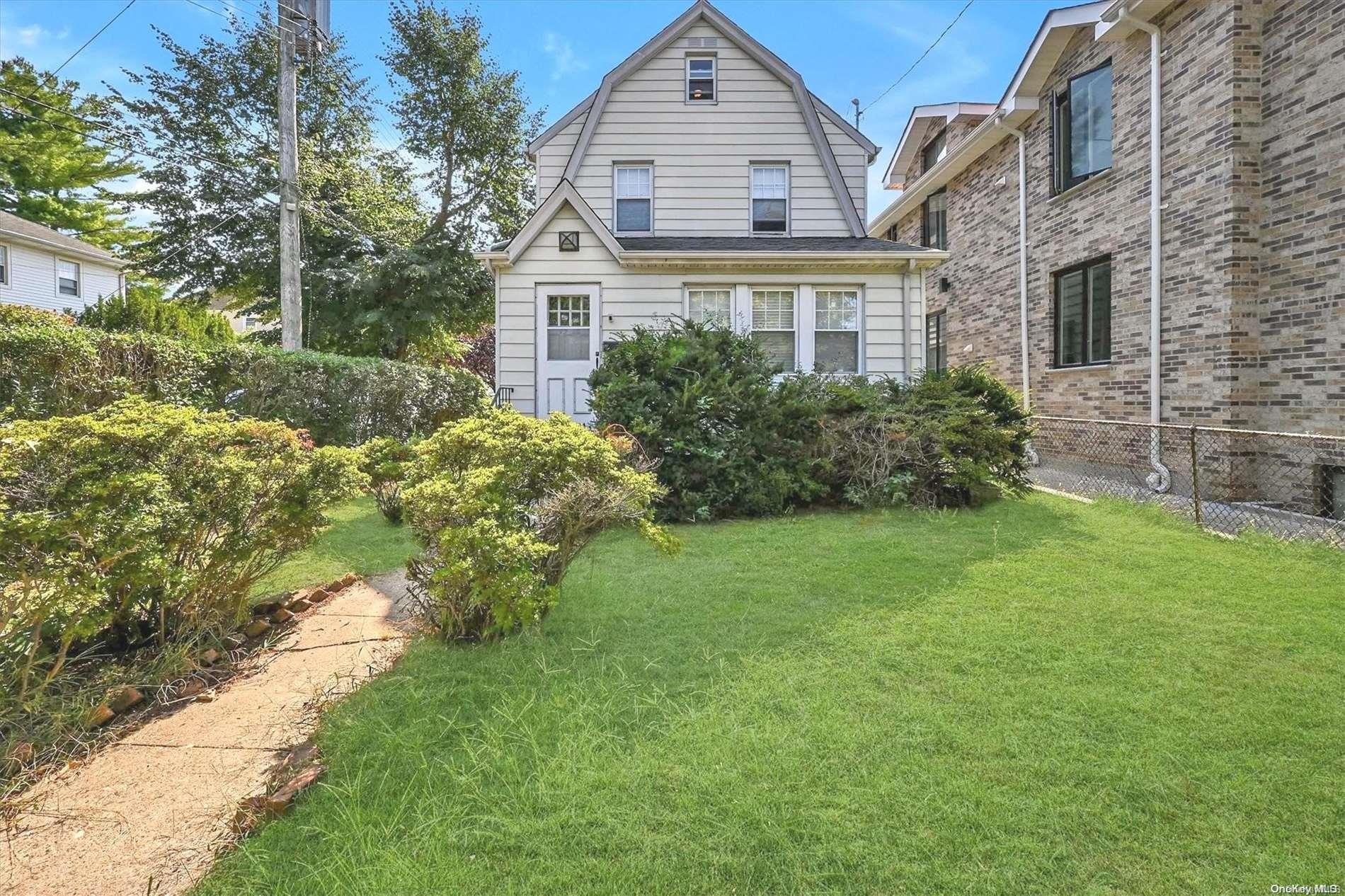 a front view of a house with a garden