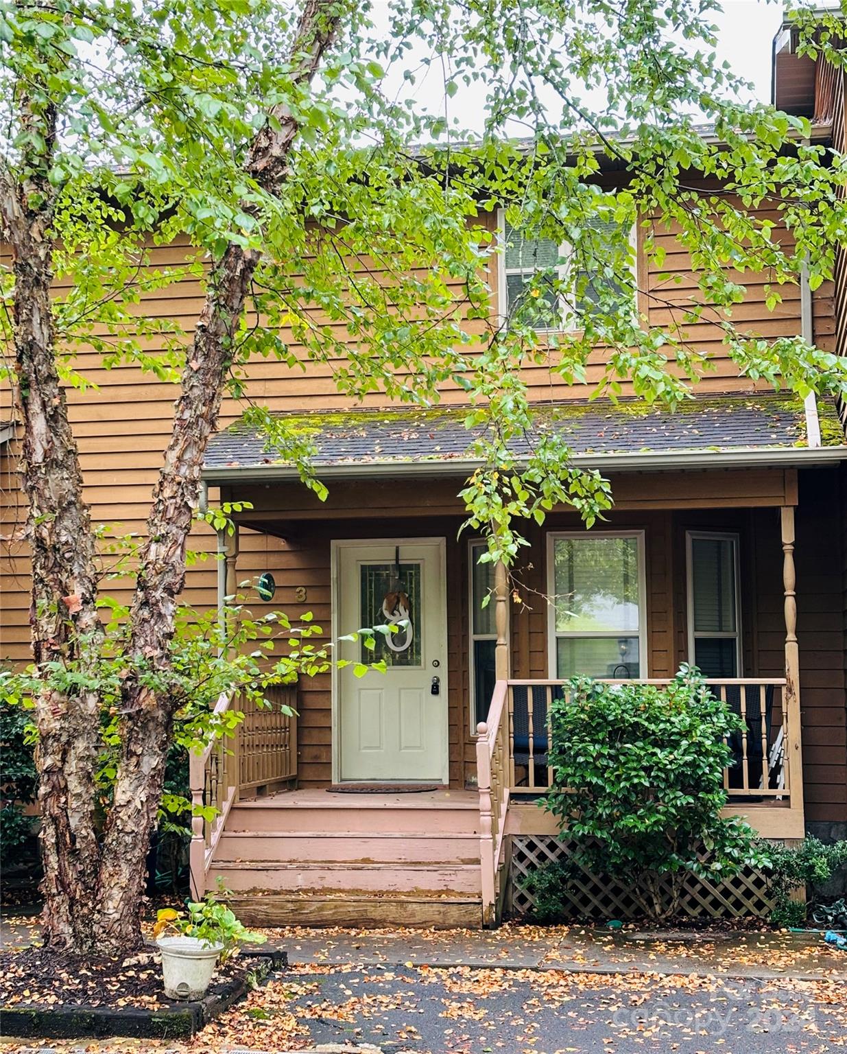 a front view of a house with a tree