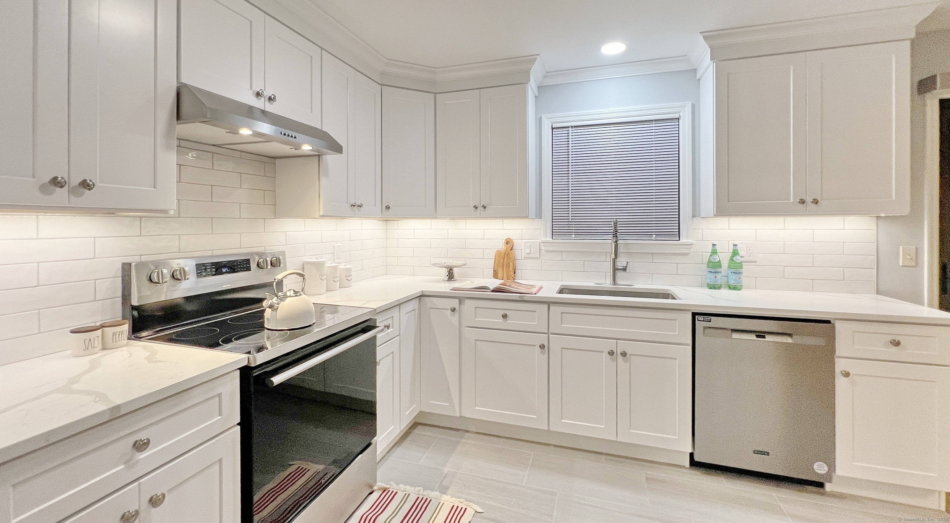 a kitchen with cabinets appliances a sink and a counter top space