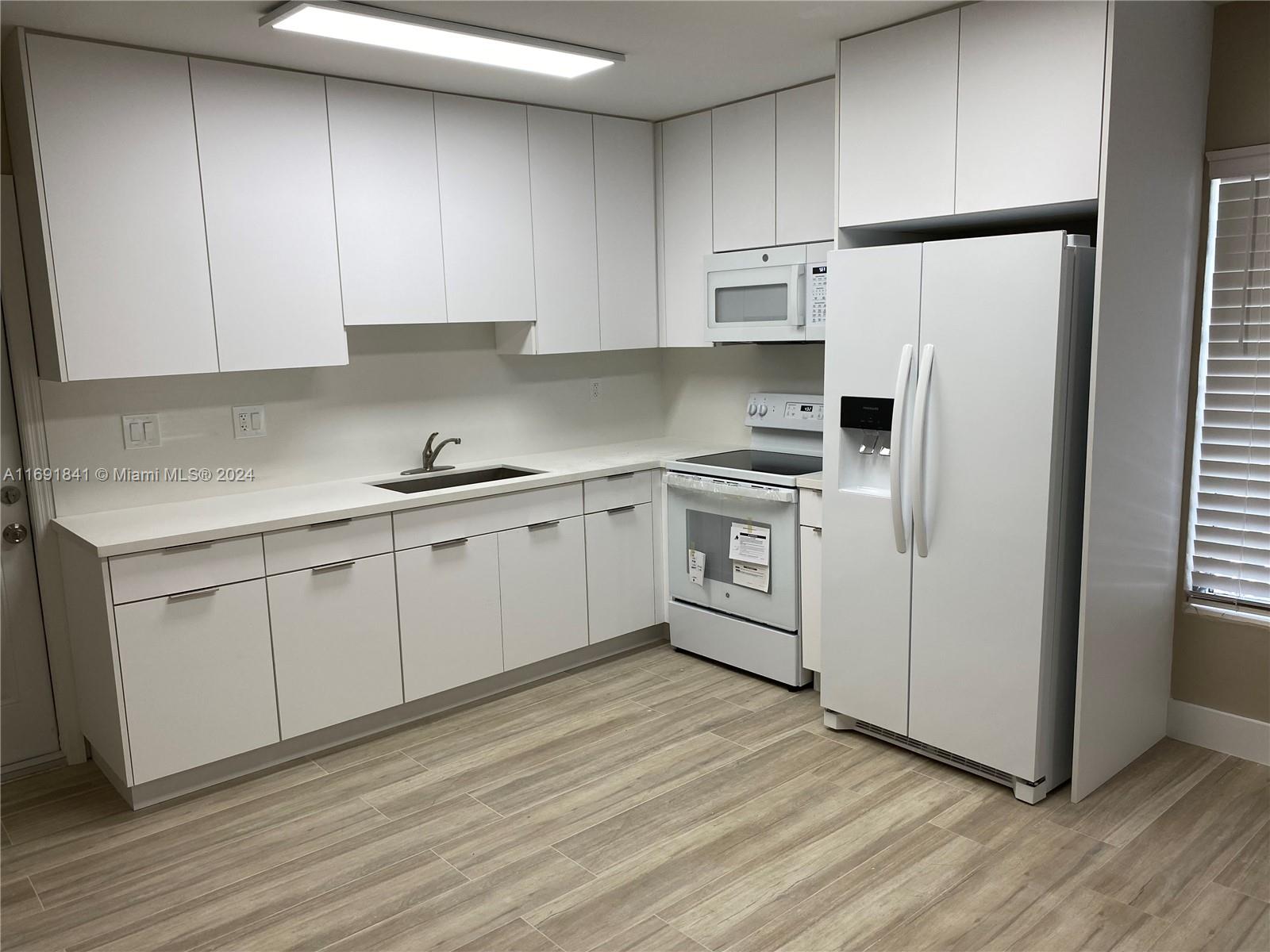 a kitchen with white cabinets stainless steel appliances and sink