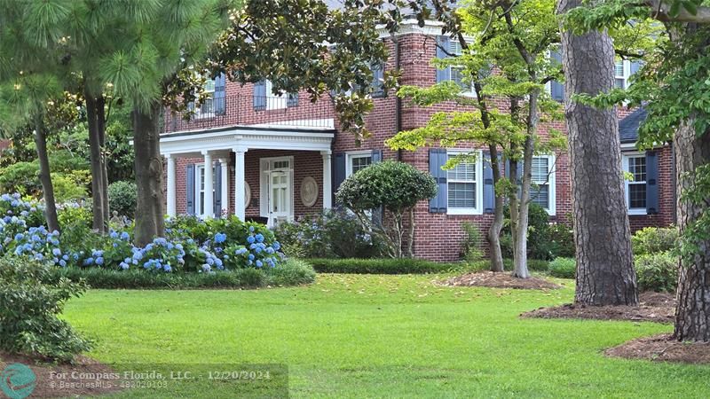 a front view of a house with a garden and plants