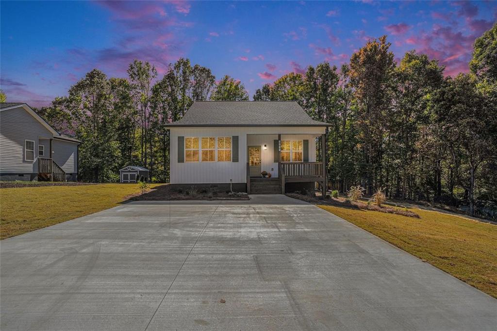 a front view of a house with yard and trees