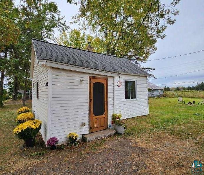 View of outdoor structure featuring a yard