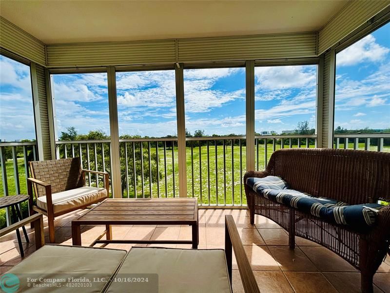 a living room with furniture and floor to ceiling windows