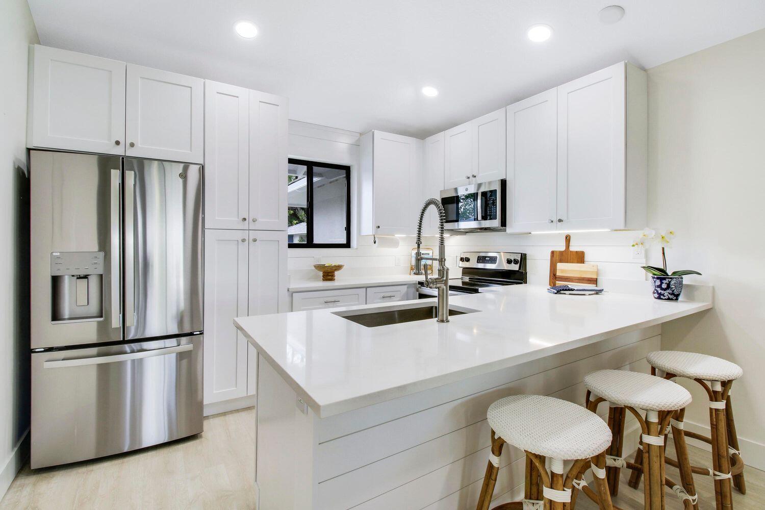 a kitchen with stainless steel appliances a refrigerator stove microwave and sink