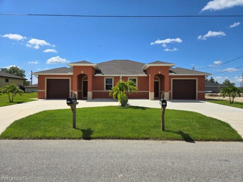 a front view of a house with a garden and yard