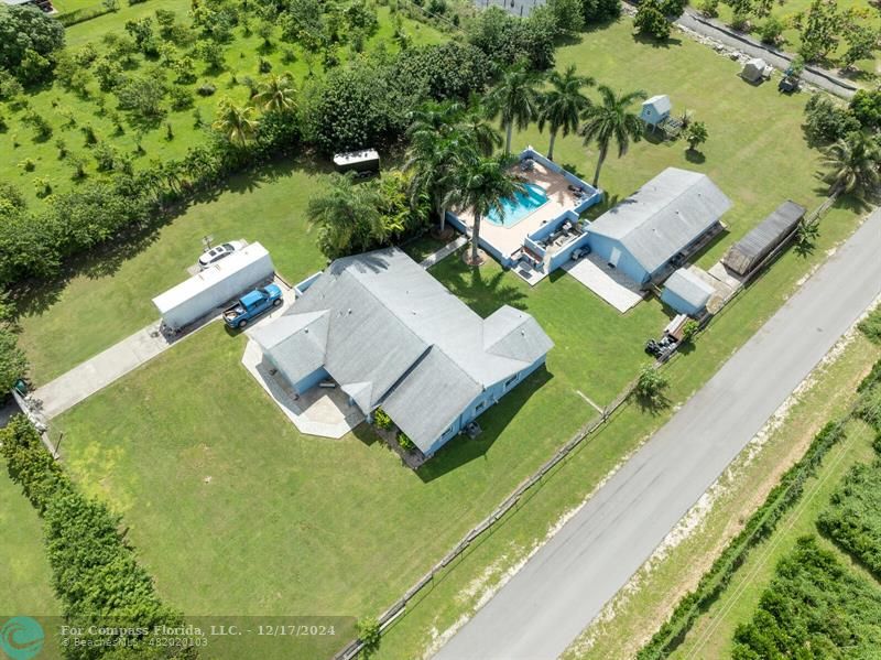 an aerial view of a house with a garden and lake view