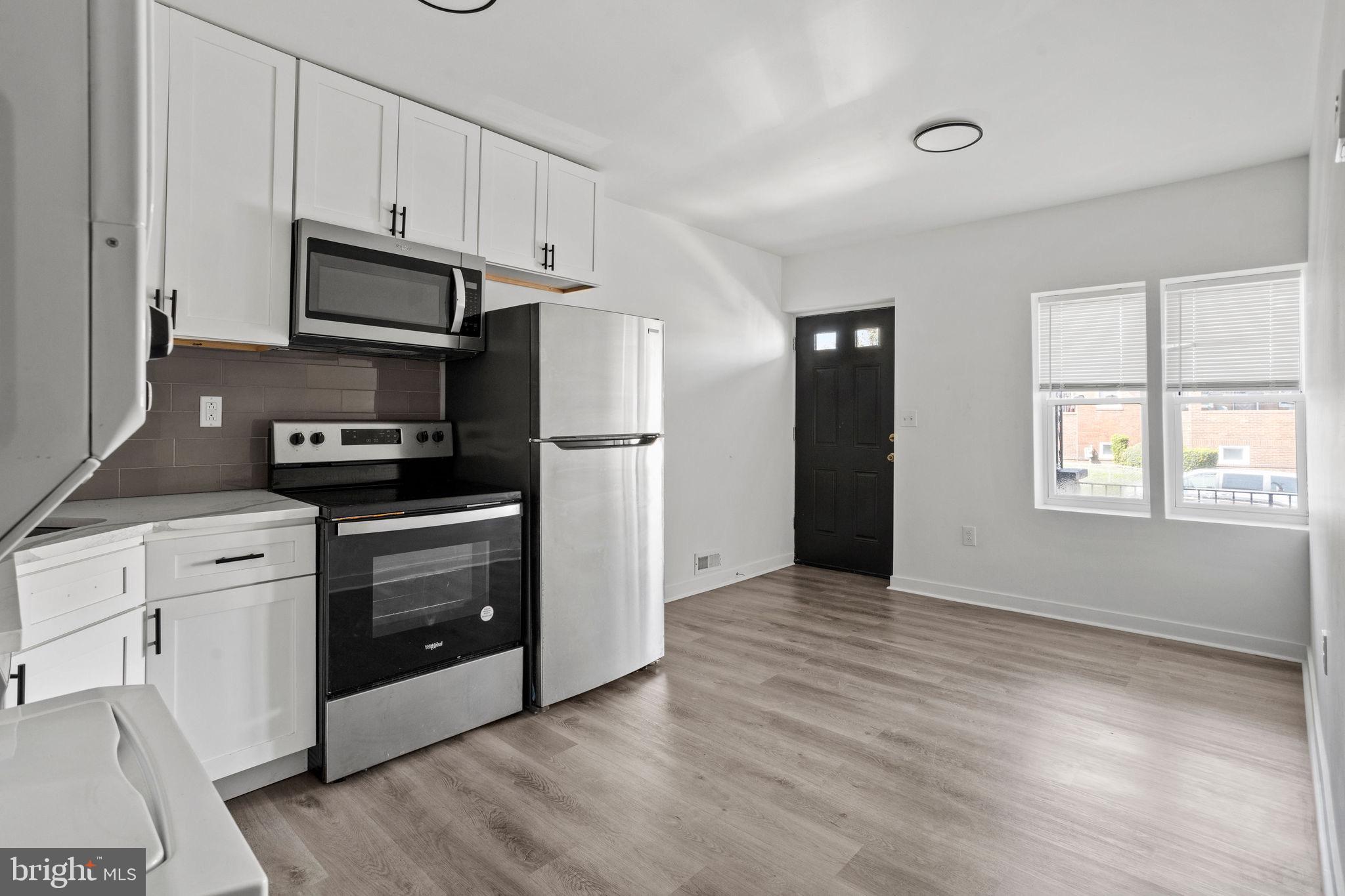 a kitchen with granite countertop white cabinets and stainless steel appliances