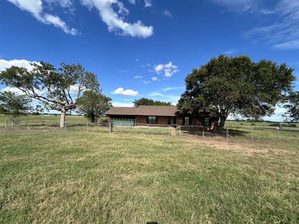 a view of a house with a yard and a tree