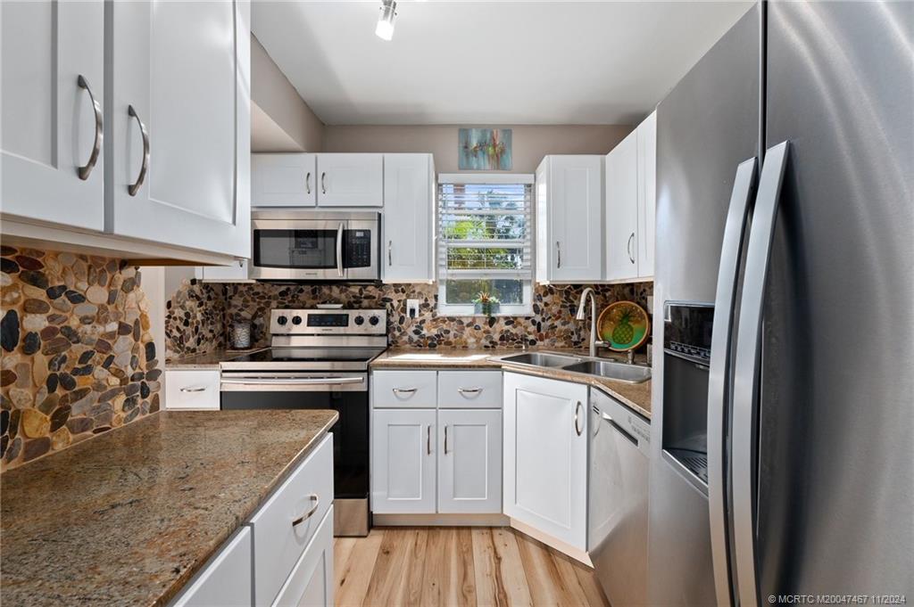 a kitchen with stainless steel appliances granite countertop a sink stove and refrigerator