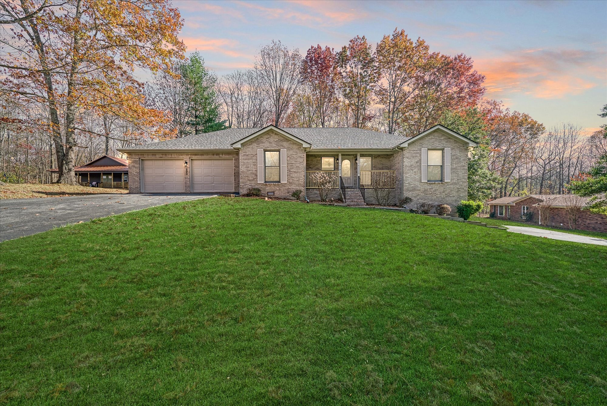 a front view of a house with yard and green space