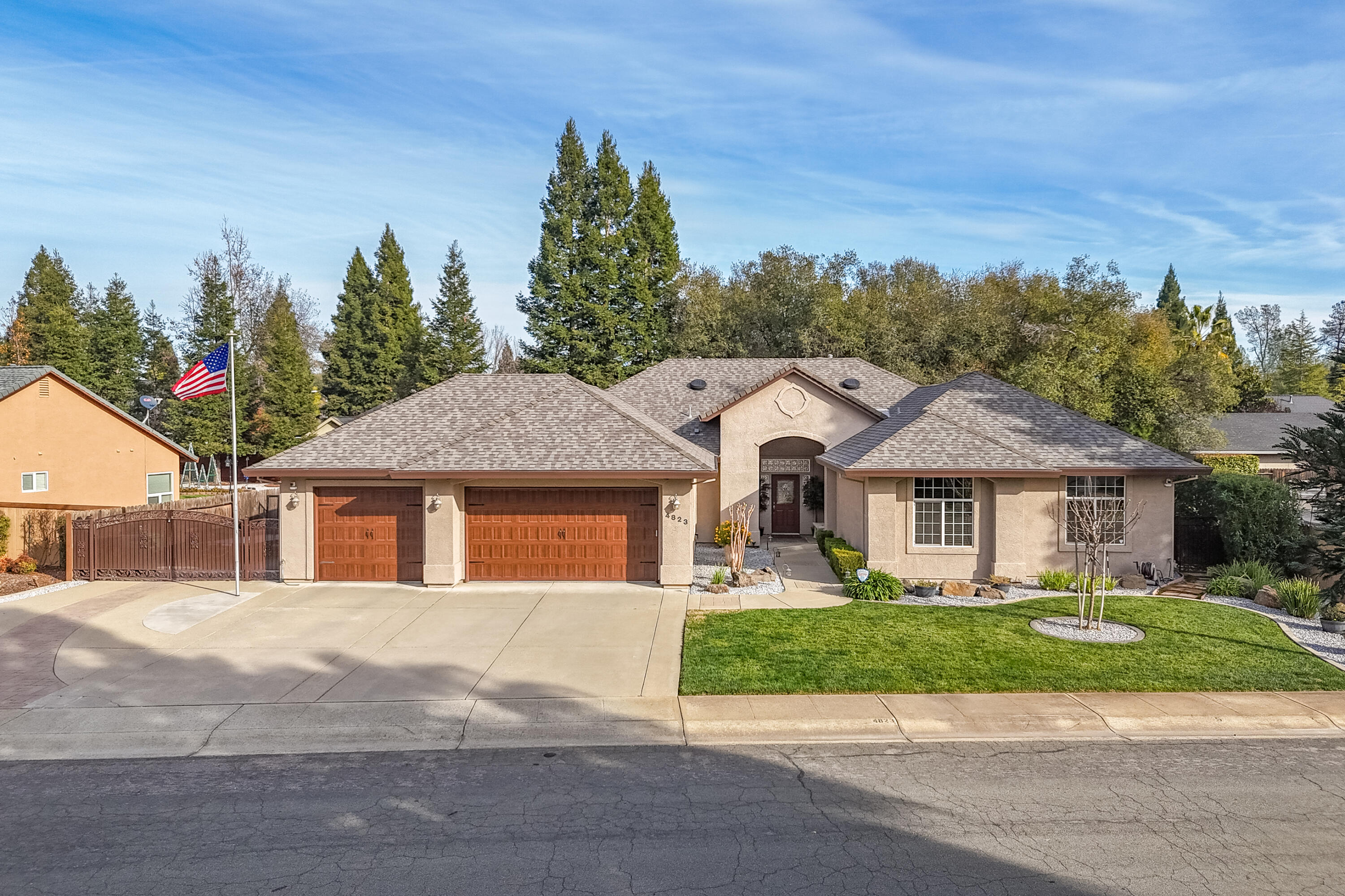 a front view of a house with a yard and trees