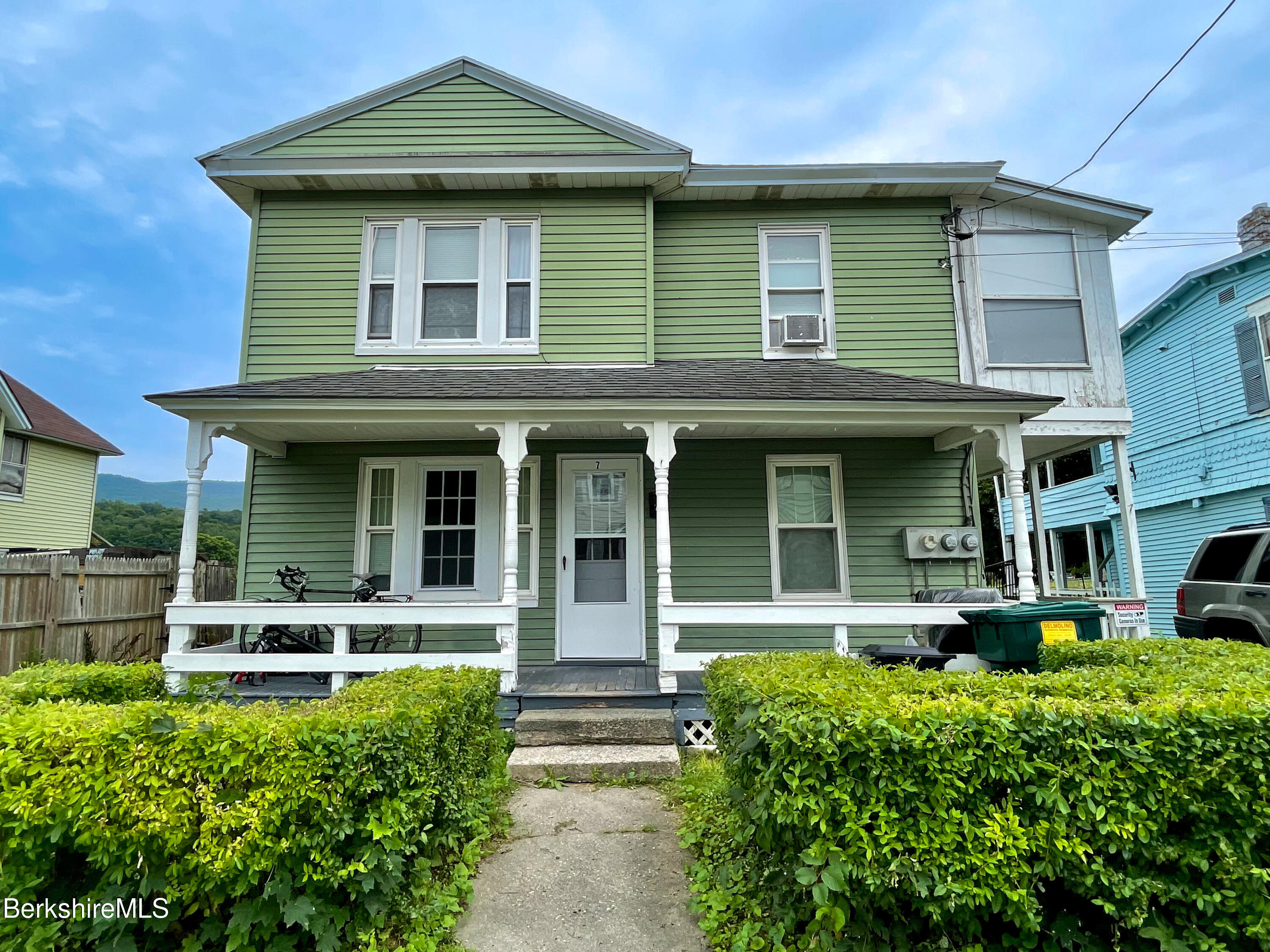 a front view of a house with plants and entryway