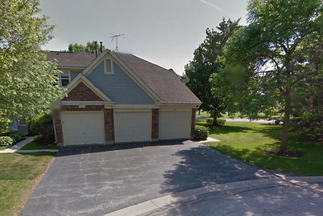 a view of a house with a yard and large tree