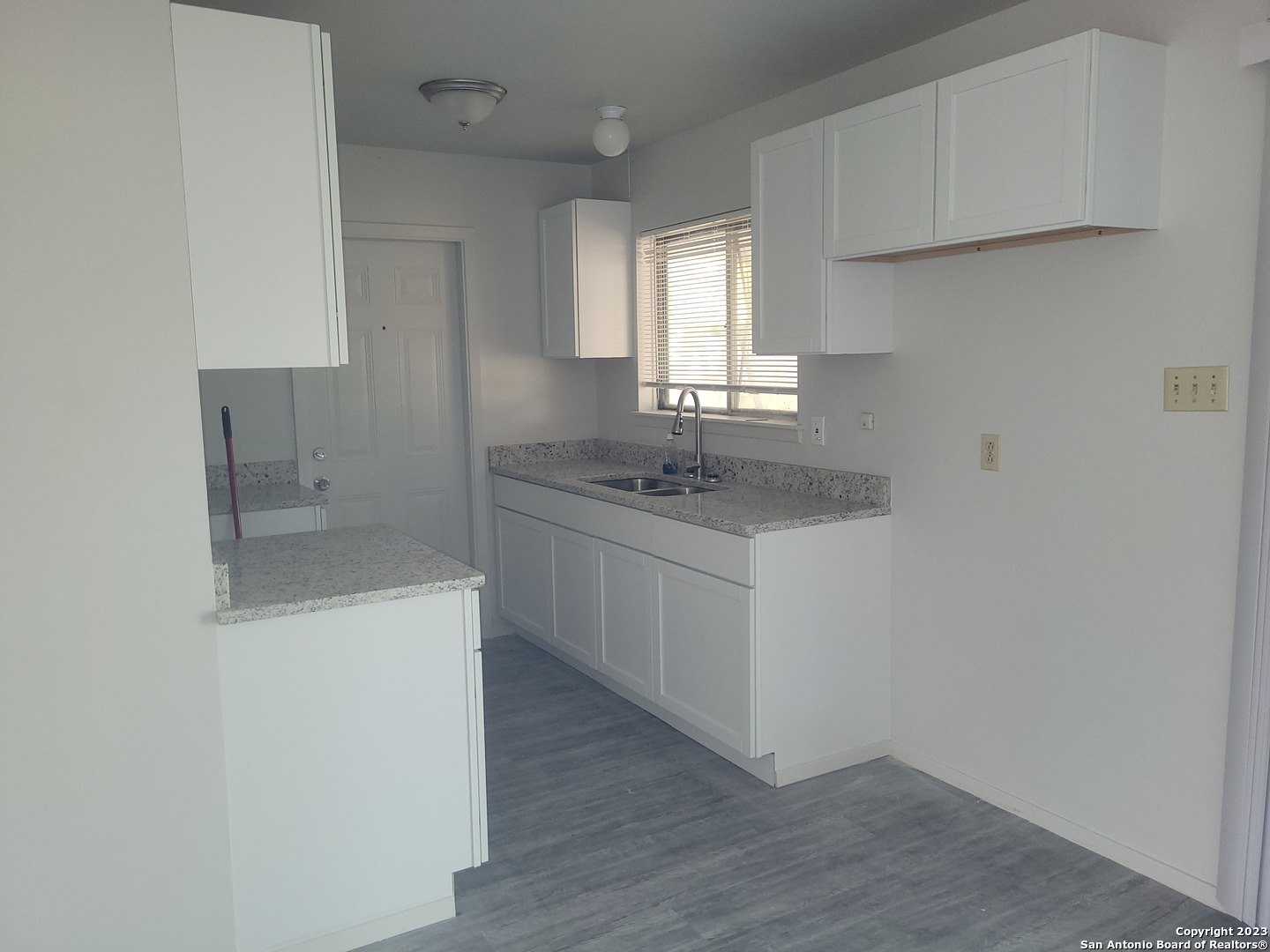 a kitchen with a sink cabinets and window