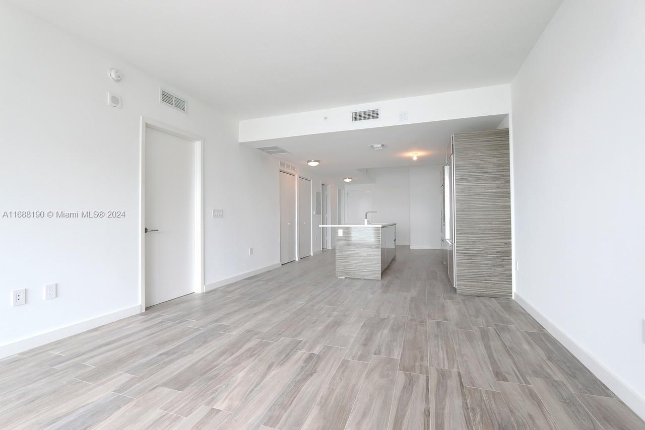 a view of a room with wooden floor