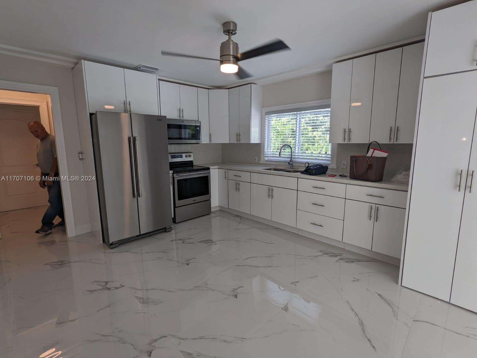 a kitchen with white cabinets and stainless steel appliances