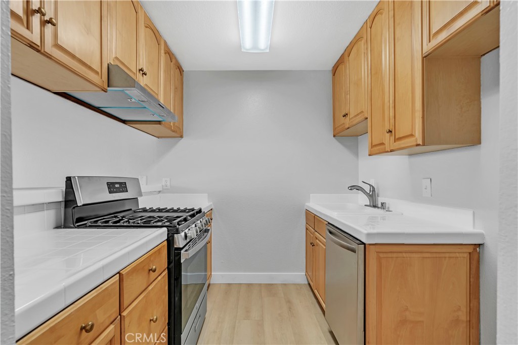 a kitchen with stainless steel appliances granite countertop a sink a stove and a refrigerator