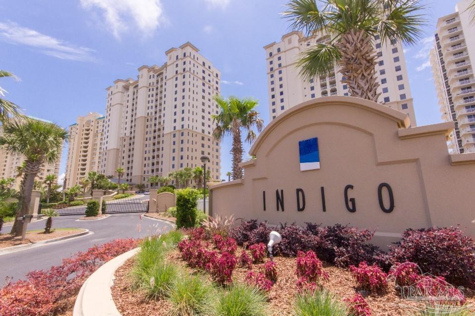 a front view of a multi story residential apartment building with yard and sign board