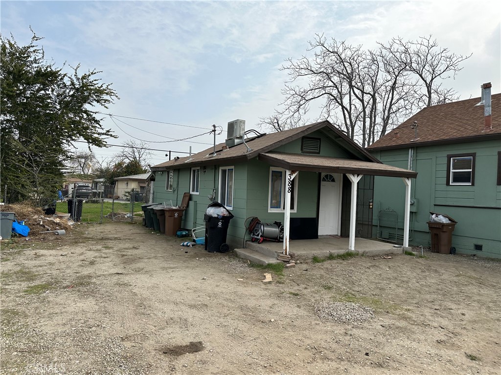 a view of a house with a yard and large tree