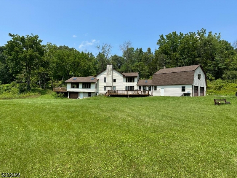 a white house with a big yard and large trees