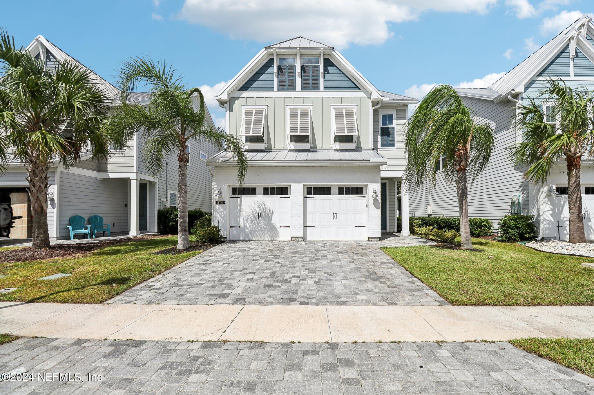 a front view of a house with a yard and potted plants