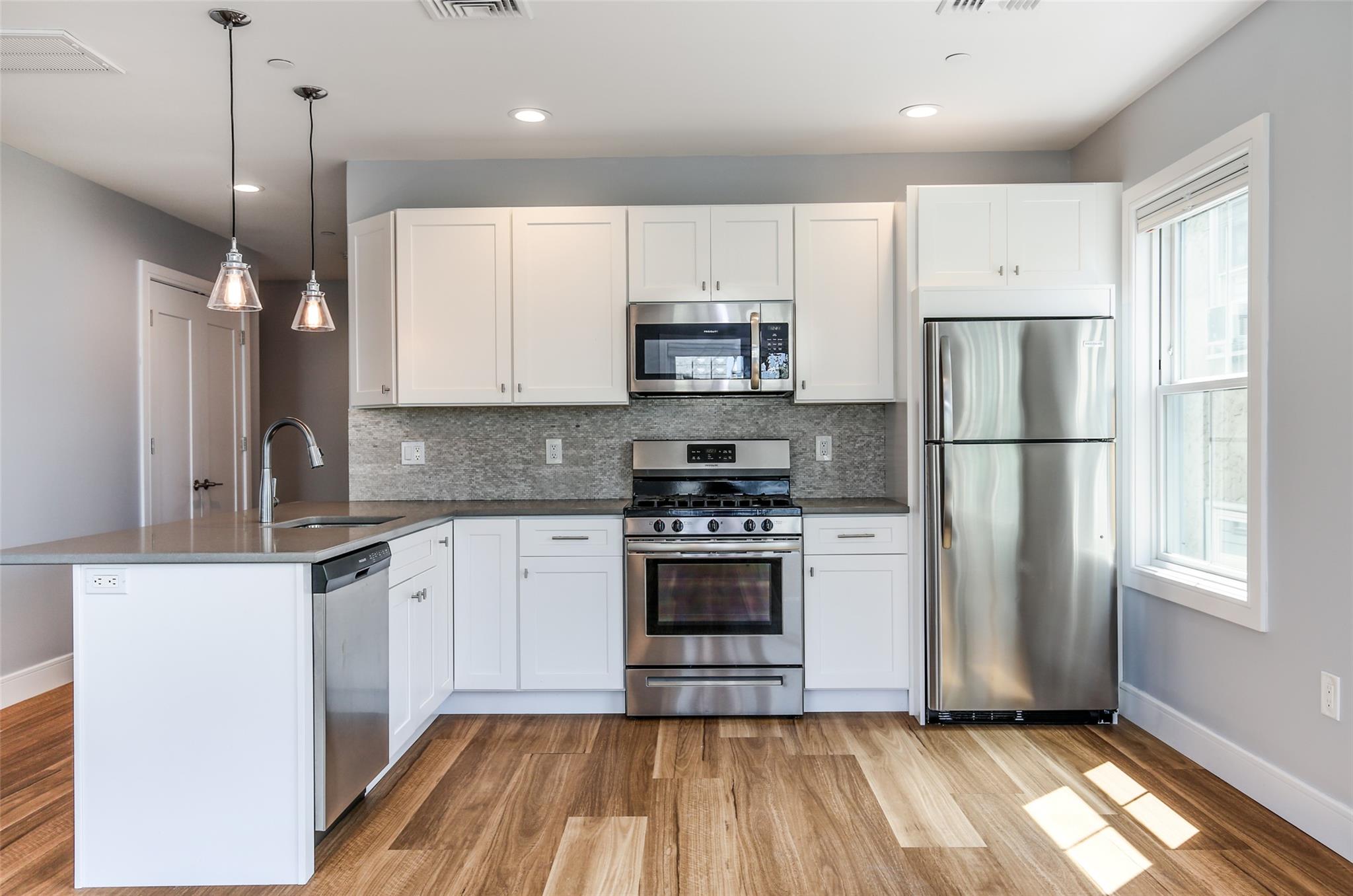 a kitchen with a refrigerator a sink and cabinets