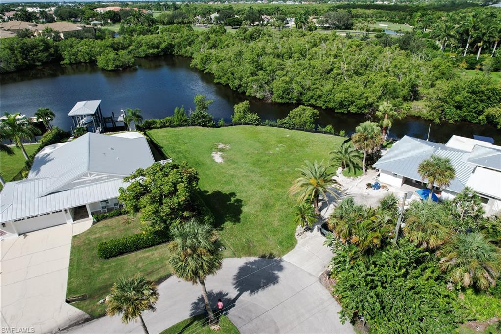 an aerial view of a house with a yard and lake view