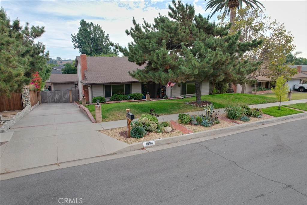 front view of a house next to a yard and a road