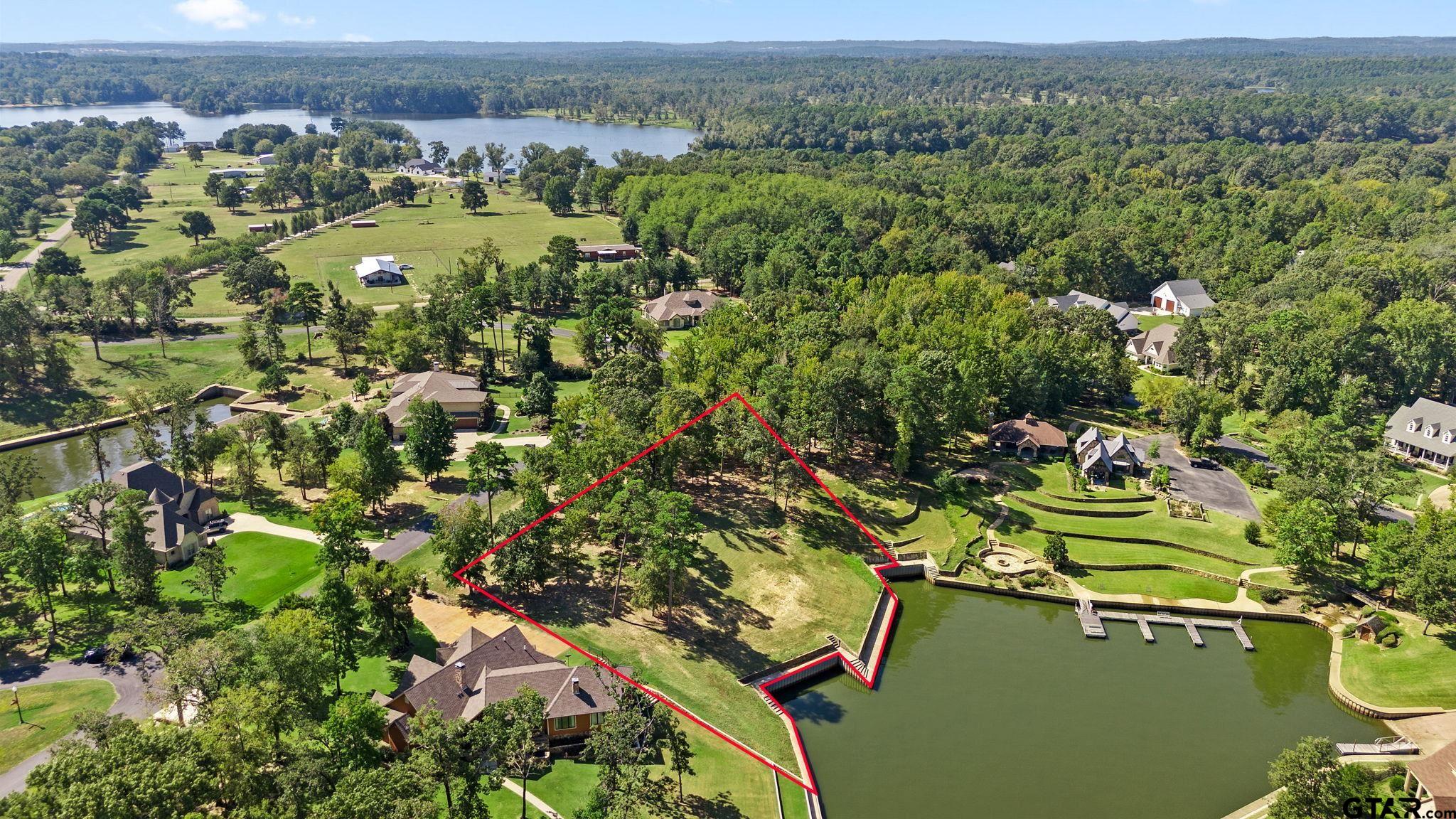 an aerial view of a house with a yard and lake view