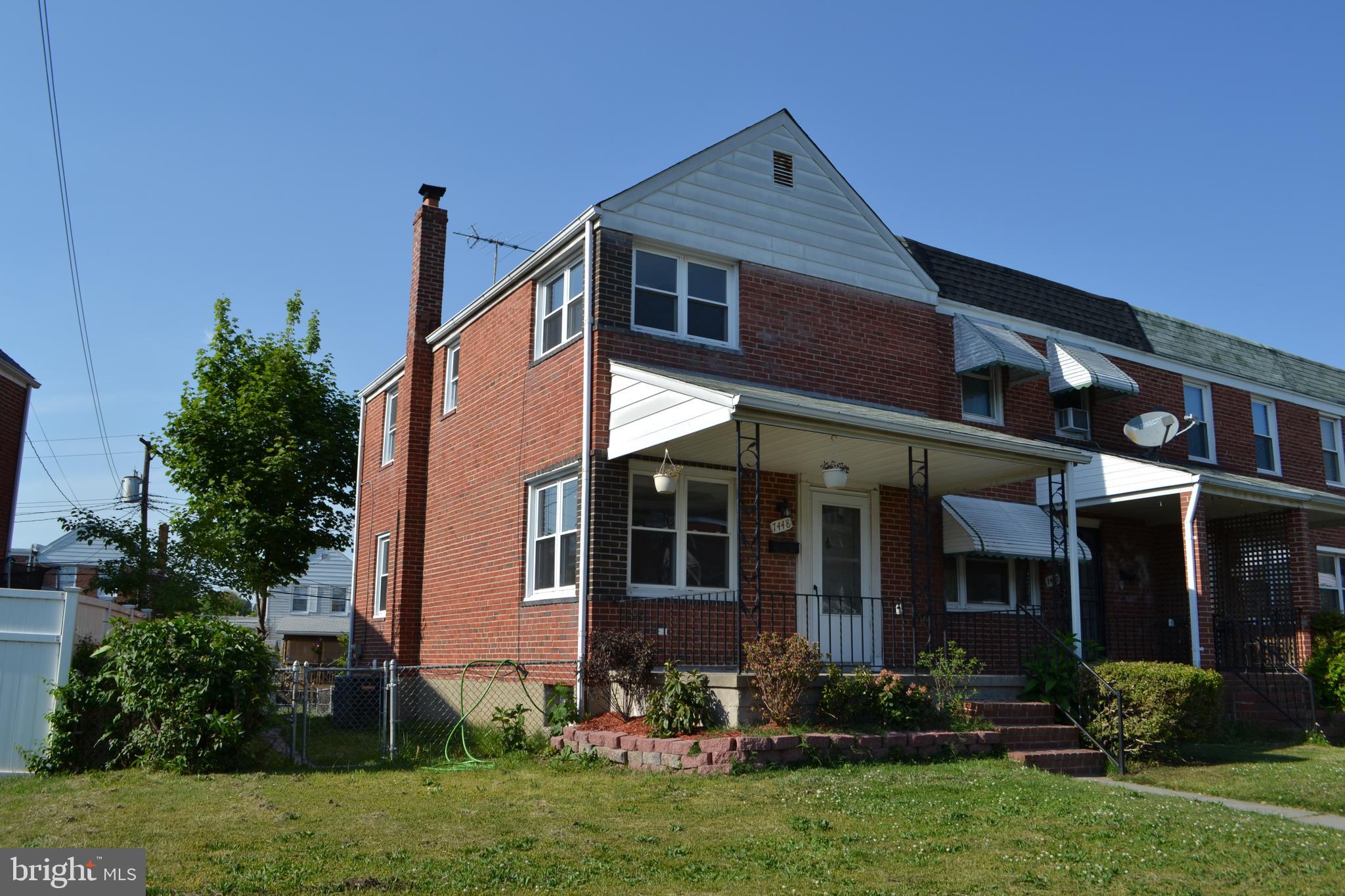 a front view of a house with a yard and potted plants