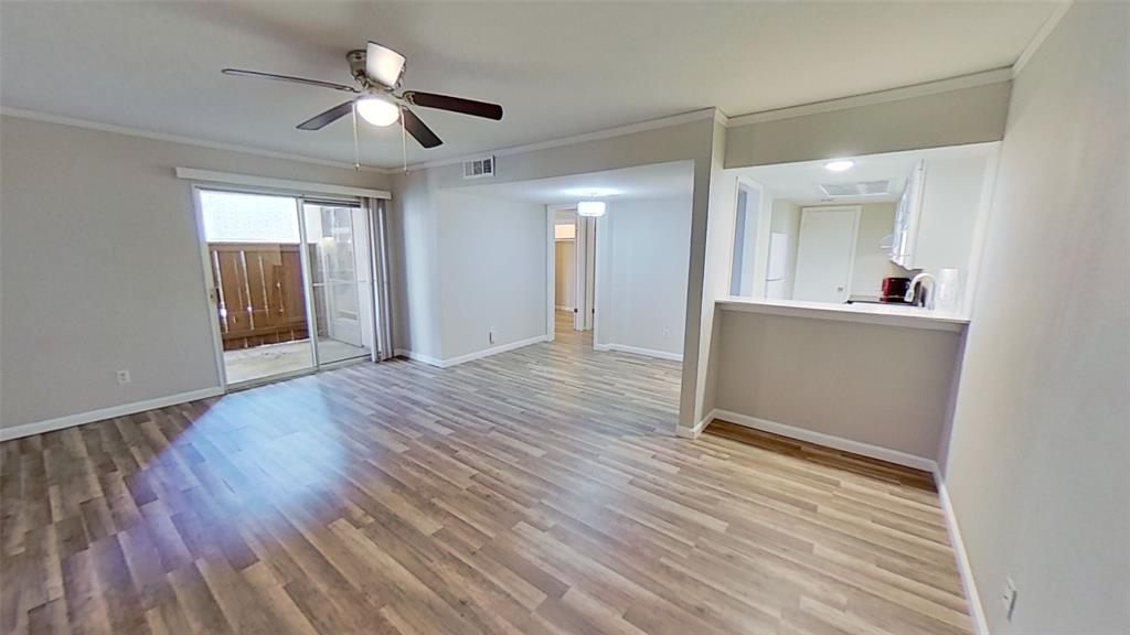 a view of a room with wooden floor and ceiling fan