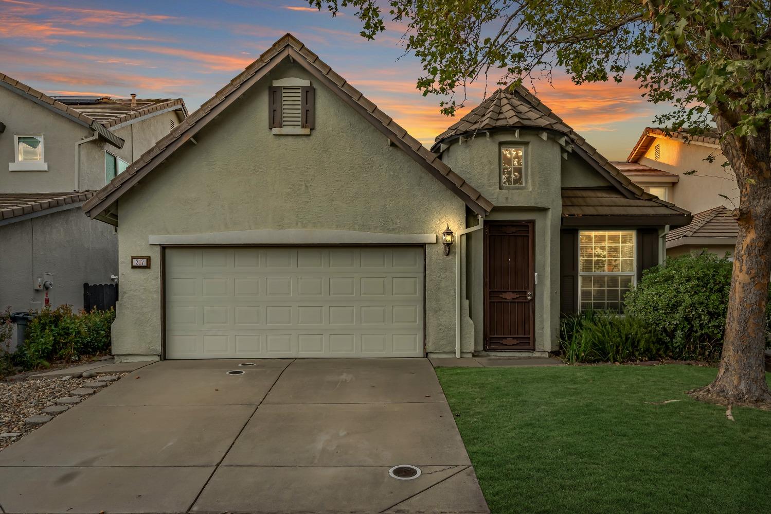 a front view of a house with a yard and garage