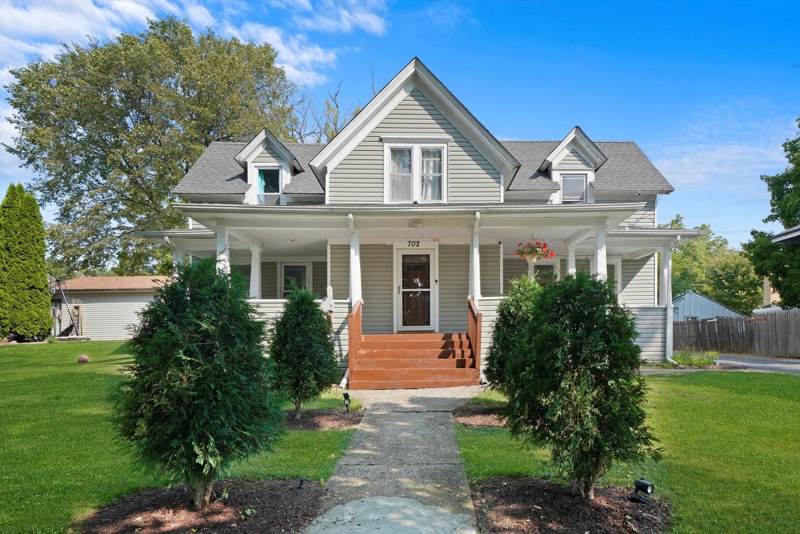 a front view of a house with a yard and potted plants