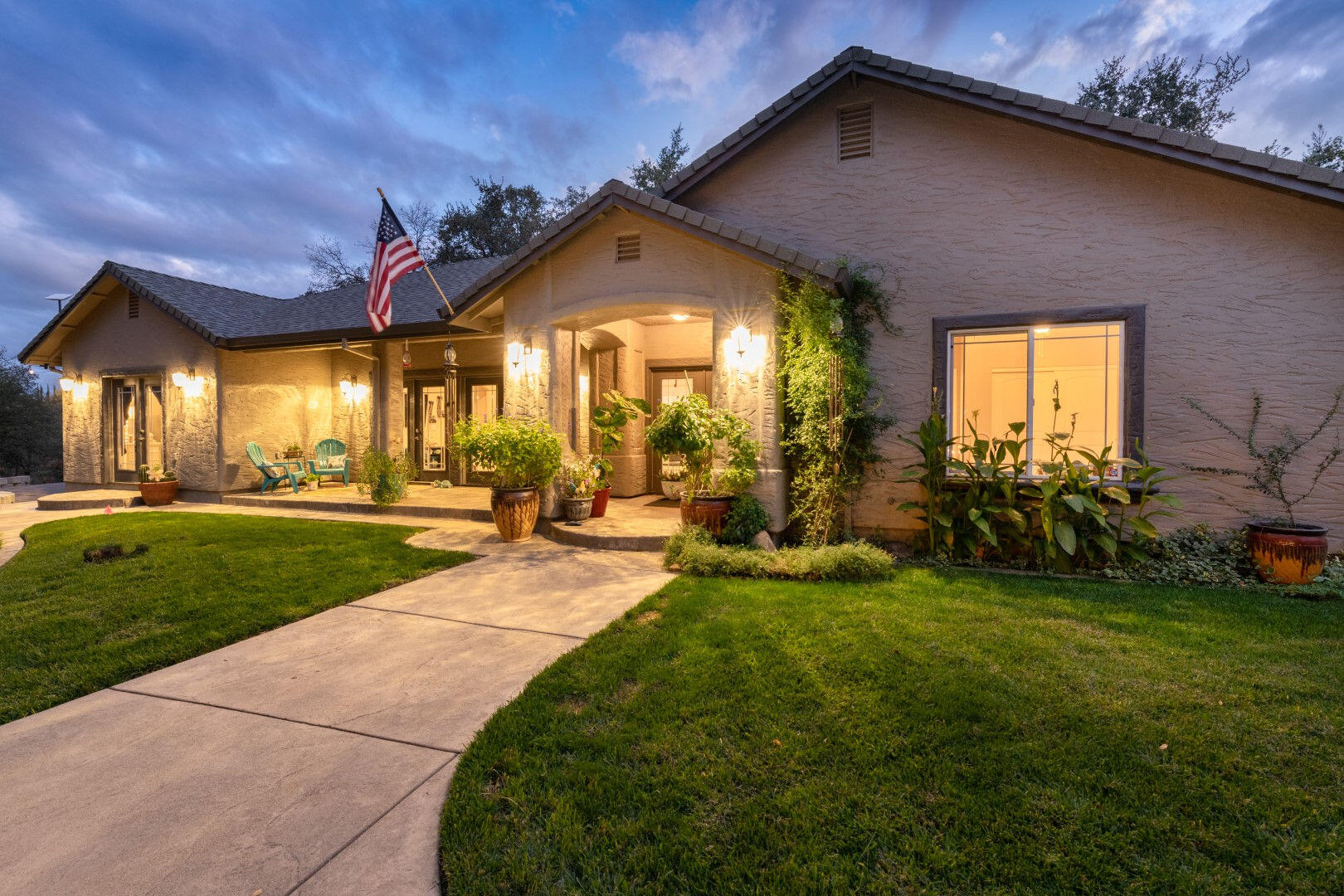 a view of a house with a big yard and potted plants