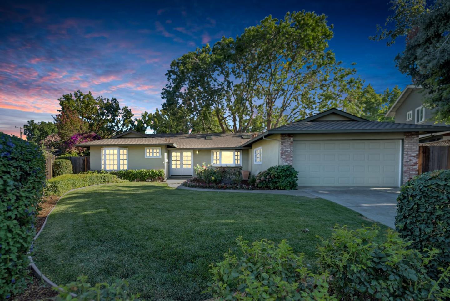 a front view of a house with a yard and trees