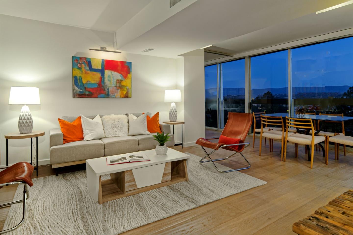 a living room with furniture a rug and a floor to ceiling window