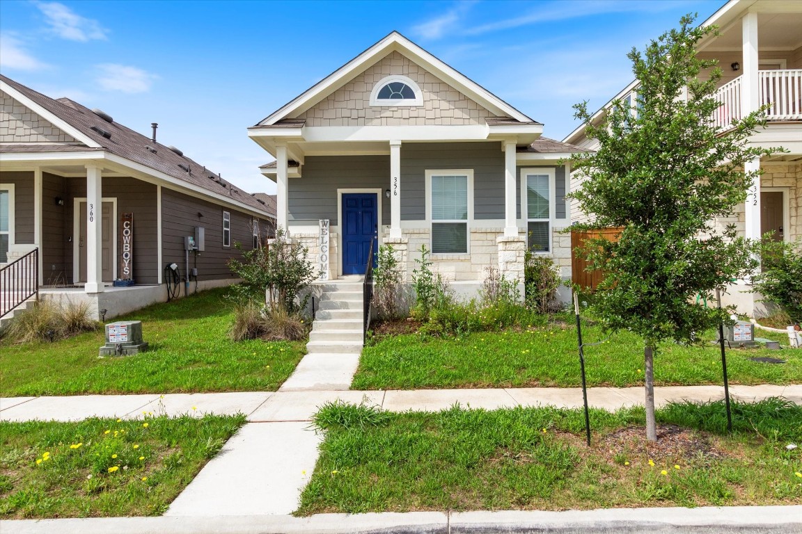 a front view of house with a yard and potted plants