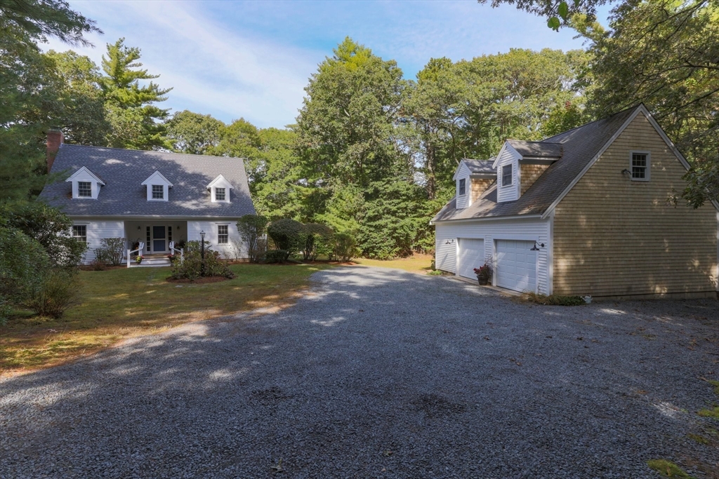 a front view of house with yard and trees in the background