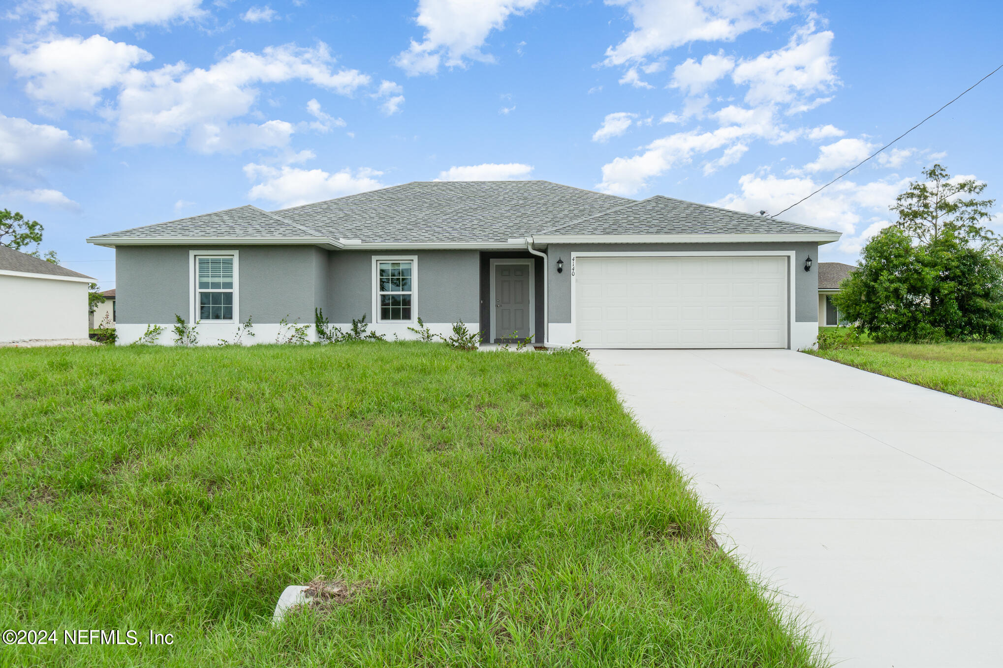 a front view of a house with yard and green space