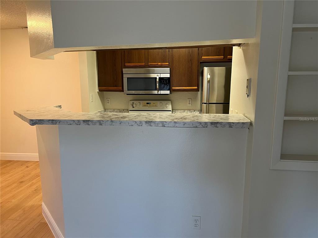 a view of a kitchen with a sink and dishwasher and wooden floor