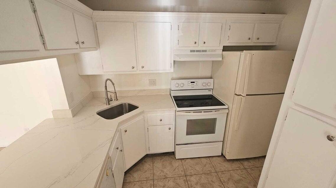 a kitchen with white cabinets and white appliances