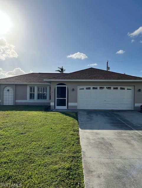 Single story home featuring a front yard and a garage