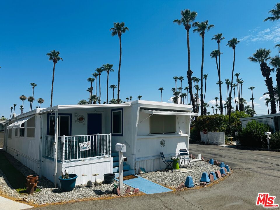 a view of a house with large windows and palm tree